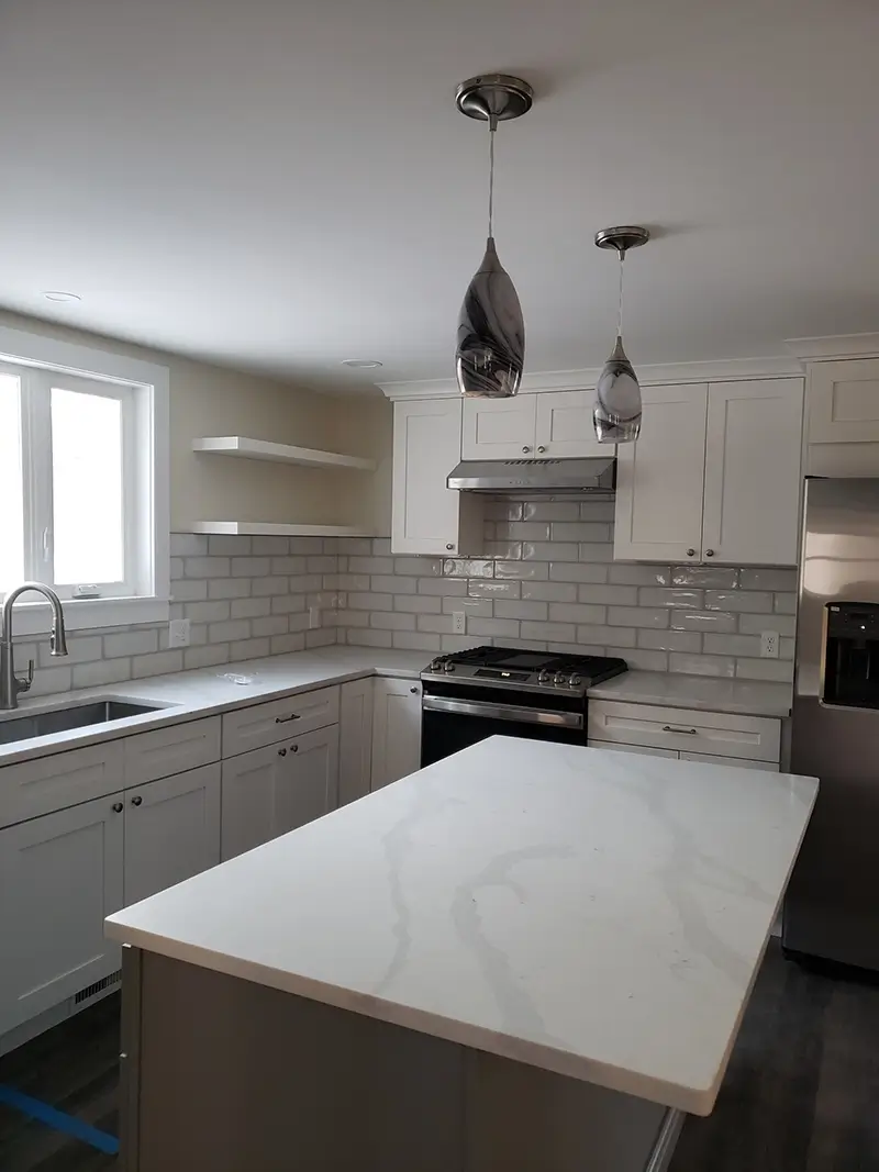 Beautifully remodeled kitchen with modern cabinets, granite, countertops, white tile, backsplash, and new appliances
