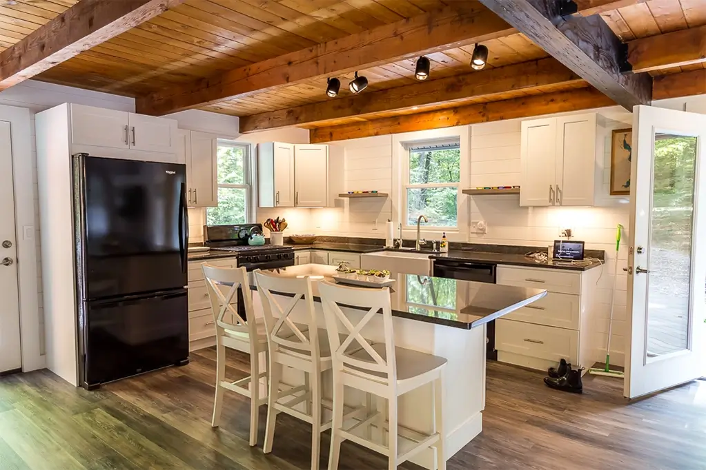 Beautifully remodeled cabin kitchen with granite countertops, kitchen island, new cabinets, and new floors
