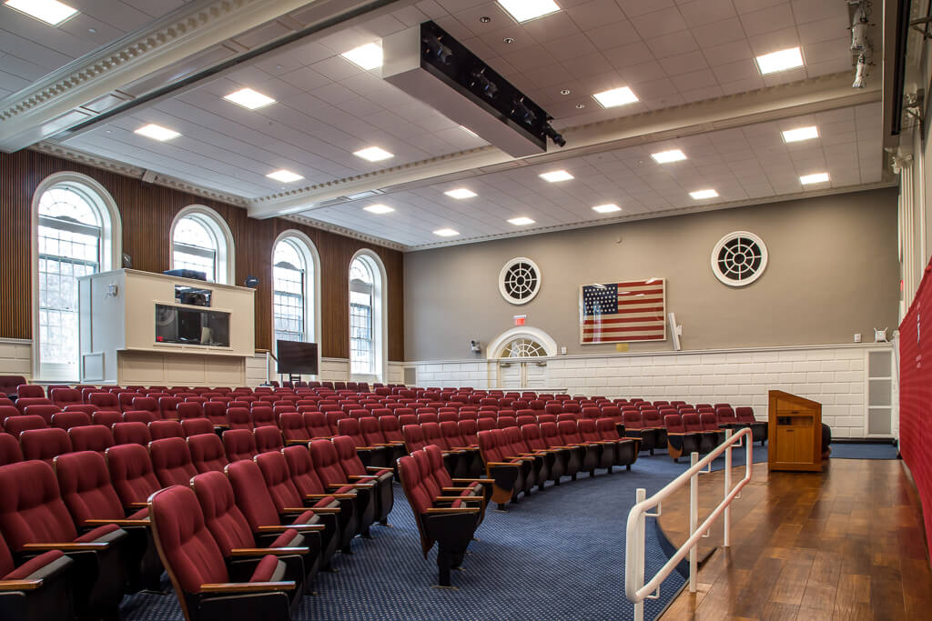 Large hall with auditorium, style seating, and arched windows