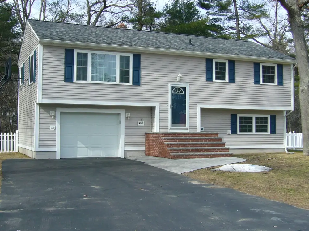 Exterior of newly renovated home with stone and brick staircase, leading to front door