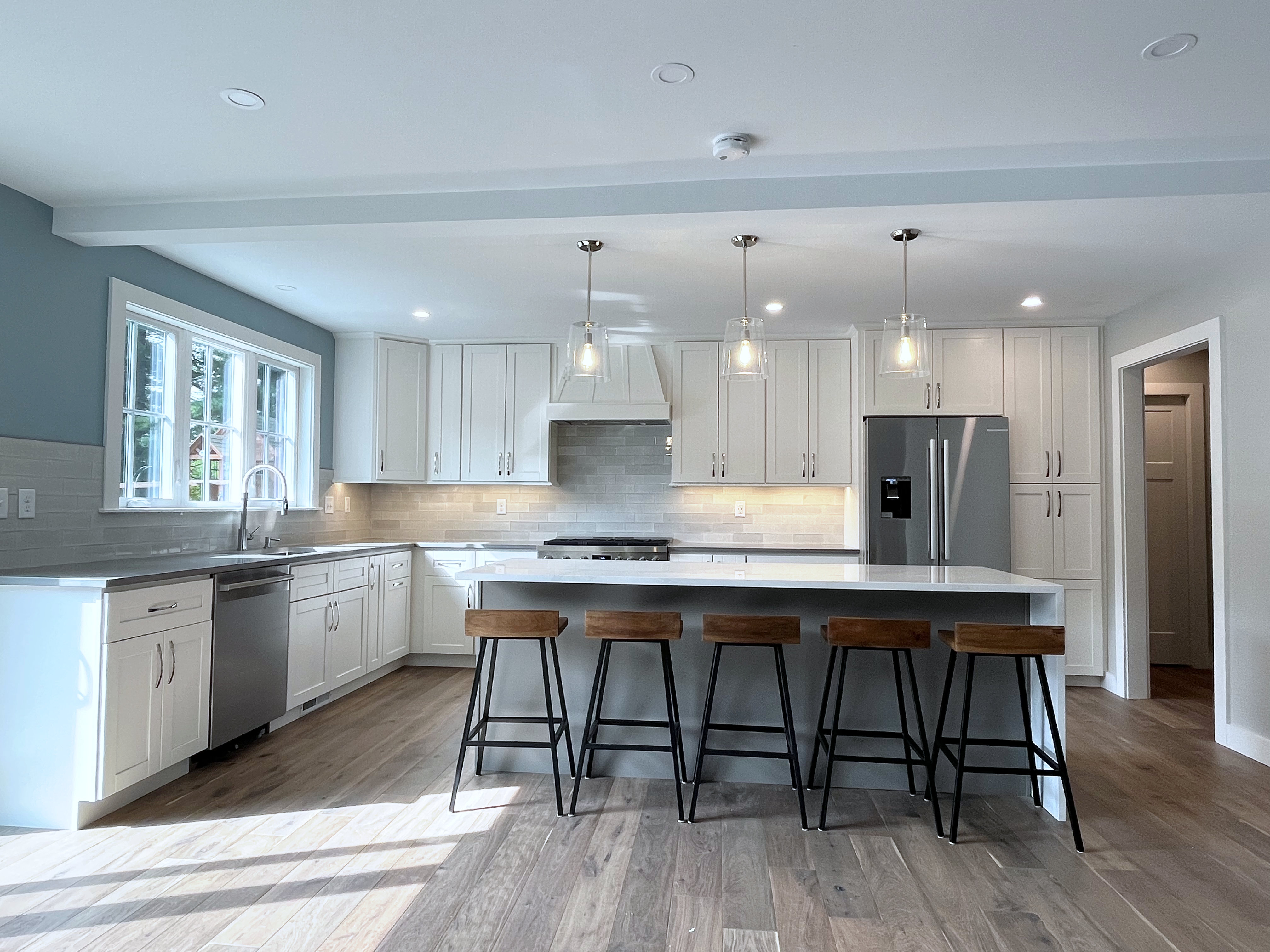 Brand new kitchen with white cabinets and new hardwood floor