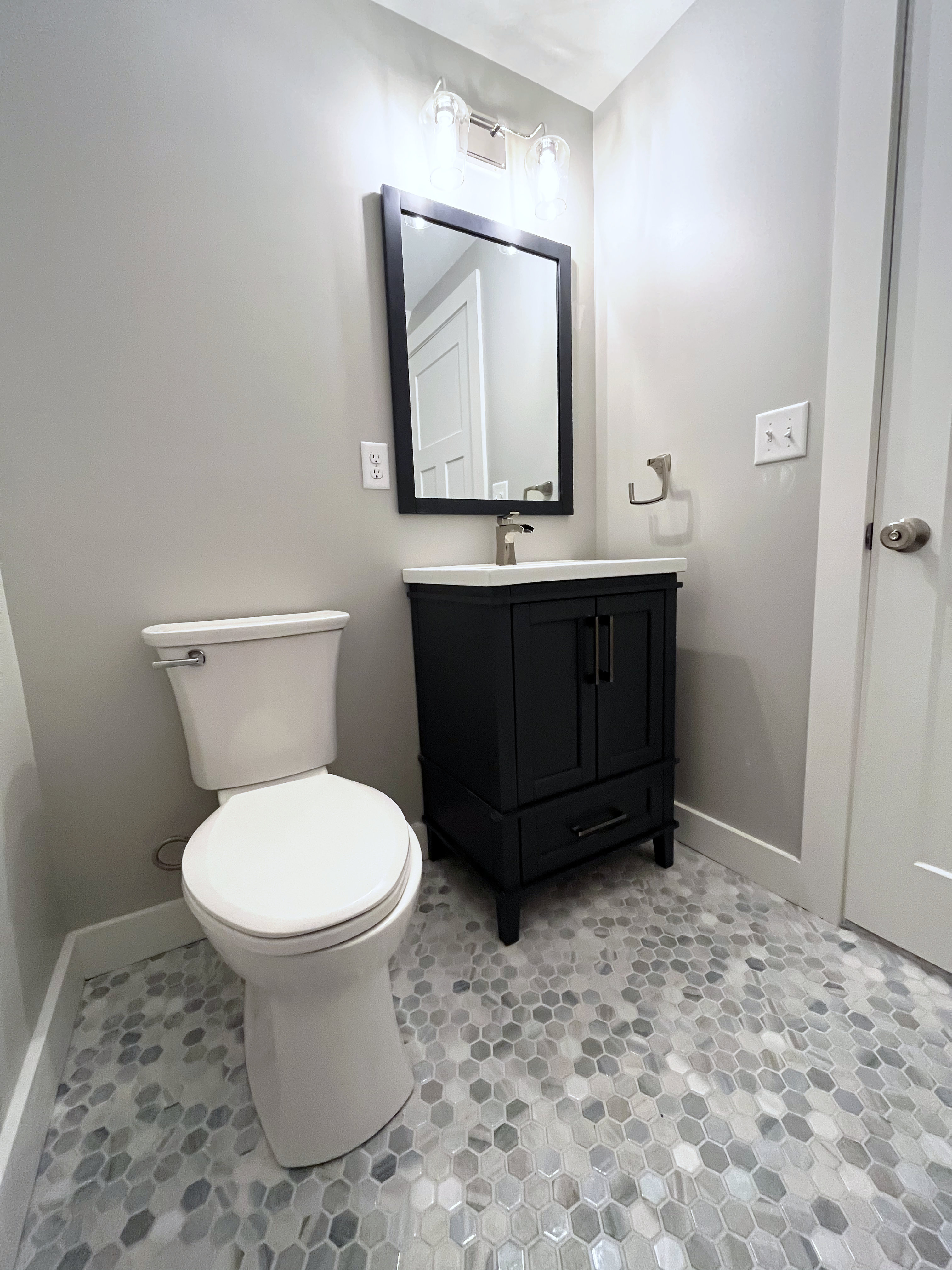 Brand new first floor half bathroom renovation with new tile, vanity and gray walls