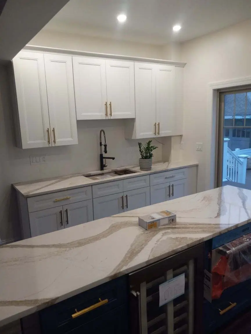 Newly remodeled kitchen with marble countertops, white cabinets, farmhouse, sink