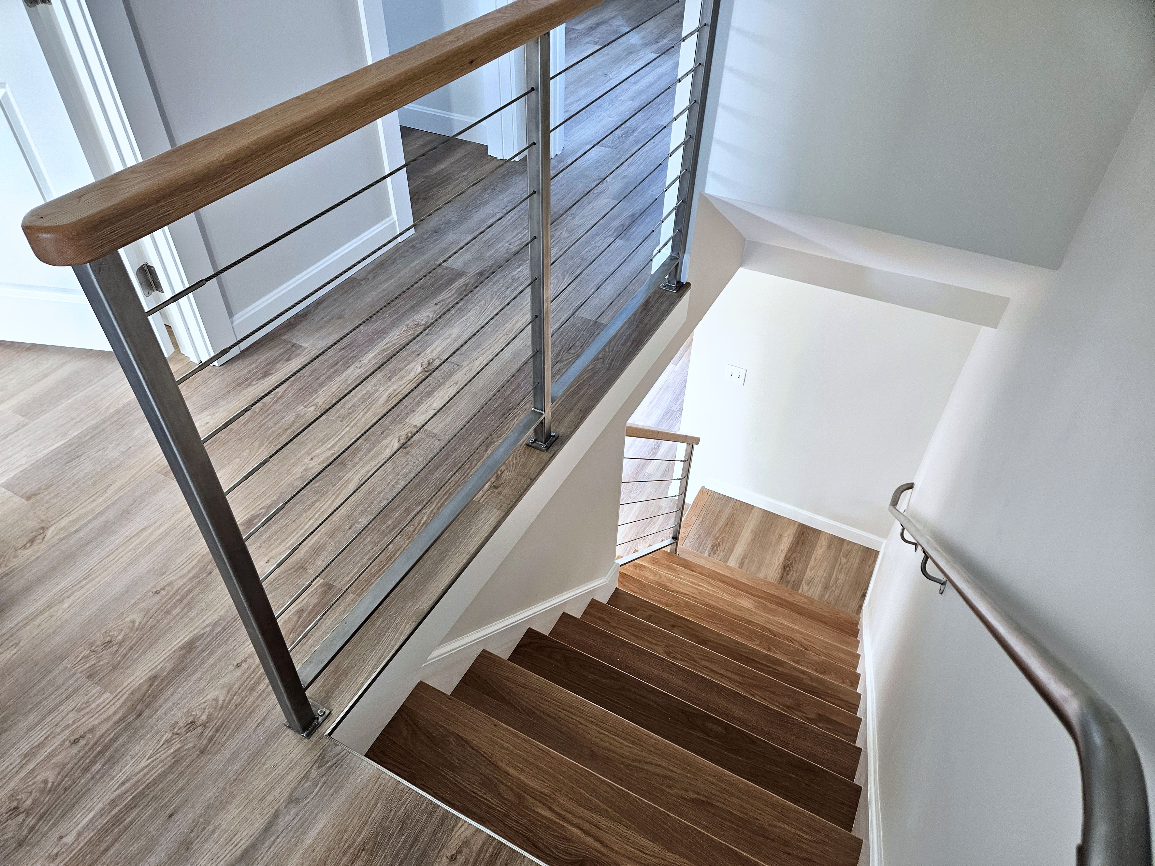 Modern staircase with cable railings and stainless steel finish