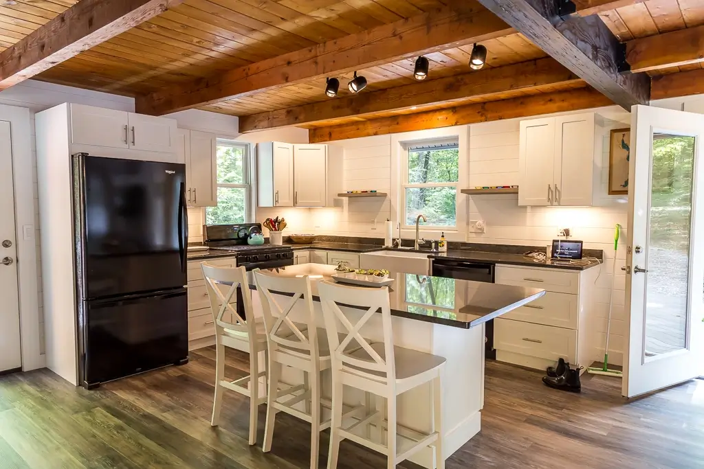 Newly remodeled cabin kitchen with hardwood floors, white cabinets, granite, countertops, and kitchen island