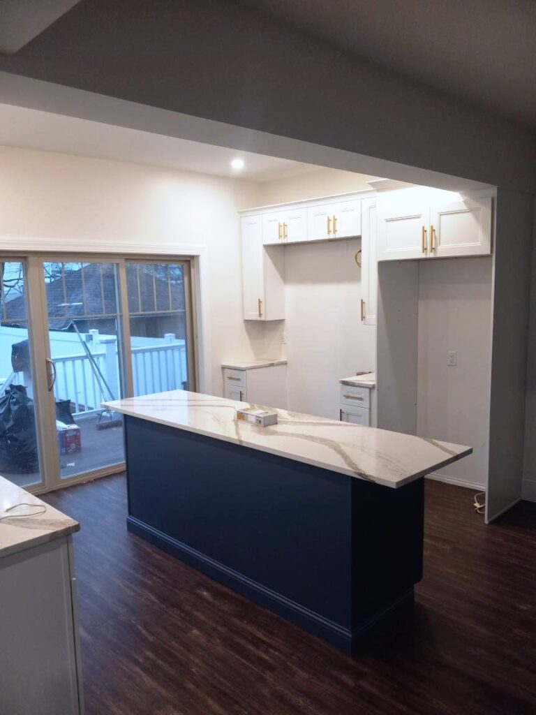 Kitchen Remodeling with beautiful granite countertops, white cabinets and navy blue island cabinet